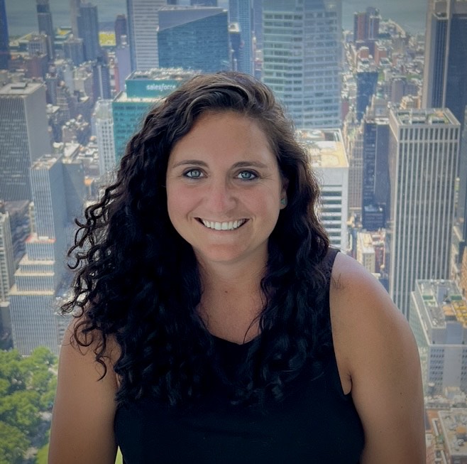 Headshot of Kendra Nicolai with a city scape in the background
