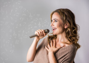 A white woman singing into a microphone